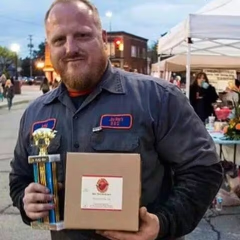 Jason Ray holding his Wyandotte ribs cook-off trophy