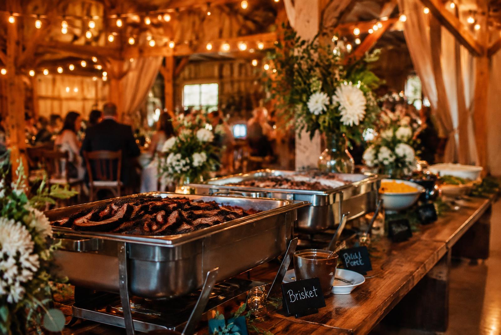 Elegant BBQ buffet at a candlelit barn wedding